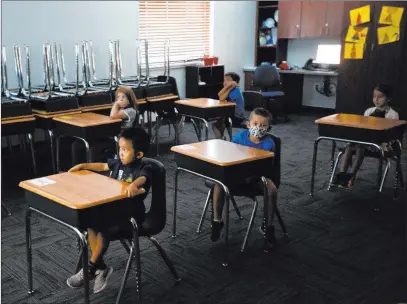  ?? Chris Day Las Vegas Review-journal ?? Children watch a video July 16 during summer camp at Legacy Traditiona­l School. Desks were positioned for 6-foot distances.