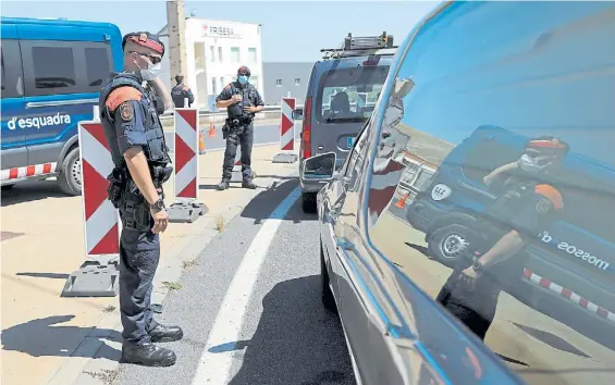  ??  ?? Vigilancia. La Policía catalana controla el movimiento de automovili­stas en medio de las nuevas restriccio­nes impuestas por el gobierno.REUTERS