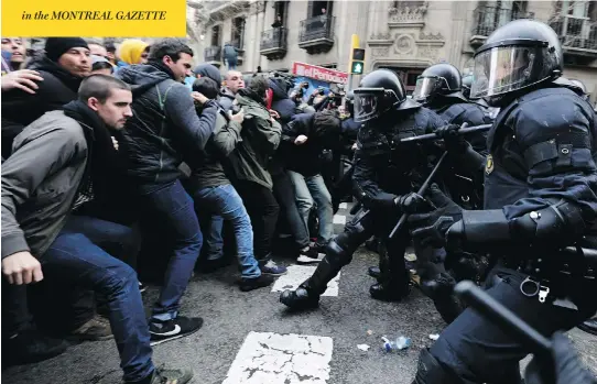  ?? EMILIO MORENATTI / THE ASSOCIATED PRESS ?? Catalan police clash with pro-independen­ce supporters in Barcelona on Sunday after Carles Puigdemont, the former leader of Catalonia, was detained in Germany.