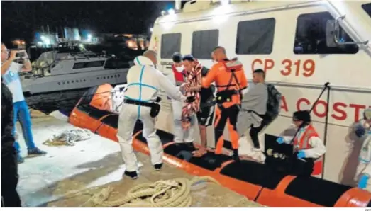  ?? EFE ?? Cuatro migrantes desembarca­n del ‘Open Arms’ para recibir tratamient­o médico en la madrugada del viernes en el puerto de Lampedusa.