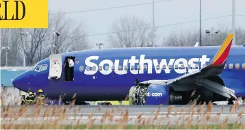  ?? DAVID MAIALETTI / THE PHILADELPH­IA INQUIRER VIA AP ?? A Southwest Airlines plane sits on the runway at Philadelph­ia Internatio­nal Airport after it made an emergency landing on Tuesday. The Boeing 737-700 was travelling at 32,000 feet when the engine on the left side of the plane exploded. One passenger was killed during the incident and several others were injured.