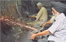  ??  ?? Labourers working on motorised grinders in oneroom manufactur­ing units making ceremonial kirpans in the vicinity of the Golden Temple in Amritsar.