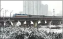  ?? YANG YONGQIAN / FOR CHINA DAILY ?? Top: A train runs through snow-clad Baoji, Shaanxi province.