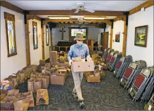  ?? MORGAN TIMMS/Taos News ?? Volunteer Paul Dunn of Taos carries out food boxes Wednesday (May 13) during Shared Table at El Pueblito United Methodist Church.
