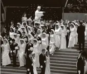  ?? Associated Press file photo ?? The Rev. Sun Myung Moon sprinkles holy water over the people he married July 1, 1982 in New York’s Madison Square Garden. The Unificatio­n Church said Moon personally matched all the couples that wed. Over 2,000 couples were married in the ceremony.