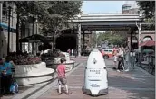  ?? MARVIN JOSEPH/WASHINGTON POST ?? A security robot patrols Washington Harbour in Washington, D.C.. Its predecesso­r drowned in a fountain.