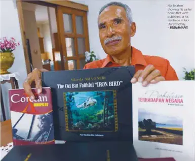  ?? BERNAMAPIX ?? Nor Ibrahim showing his earlier books that were published, at his residence in Alor Star yesterday.
–