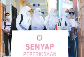  ?? .-Bernama photo ?? SPM candidates entering the examinatio­n hall at Sekolah Menengah Kebangsaan Sandakan yesterday