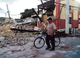  ?? PEDRO PORTAL pportal@miamiheral­d.com ?? A resident surveys the damaged buildings in the town of Guayanilla on the southern coast of Puerto Rico on Thursday.