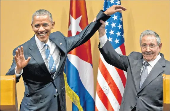  ?? RAMON ESPINOSA/AP ?? Cuban President Raul Castro, right, lifts up the arm of President Barack Obama at the conclusion of their joint news conference at the Palace of the Revolution on March 21, 2016, in Havana, Cuba.