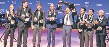  ?? — AFP photo ?? David Beckham (third left) along with Miami dignitarie­s and investors celebrate during an event to announce Beckham’s new Major League Soccer franchise in Miami, Florida.