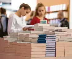  ?? Fotos (3): Boris Roessler, dpa ?? Berge von Büchern, und alle fix und fertig geschriebe­n und gedruckt. Nur in Halle 3.0, Stand K 12, fängt die Arbeit erst an.