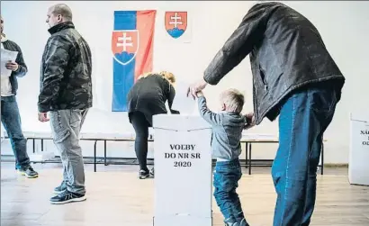  ?? JAKUB GAVLAK / EFE ?? Un niño introduce en la urna el voto de su padre, ayer en un colegio electoral de la ciudad de Trnava