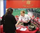  ??  ?? DeKalb County Fire Rescue Department youth developmen­t administra­tor Annette Haygood speaks with a potential recruit during Friday’s fair.