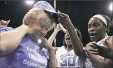  ?? Janet Blackmon Morgan/The Sun News via AP ?? North Carolina coach Sylvia Hatchell, left, is greeted by her players after their 79-63 win against Grambling State in Myrtle Beach, S.C. Hatchell earned her 1,000th career coaching victory with the win.