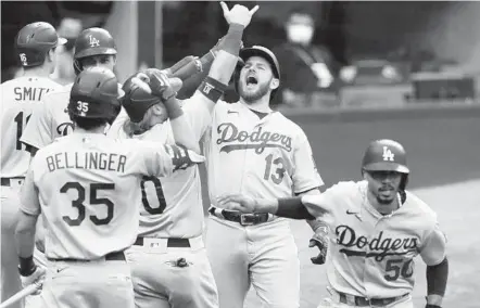  ?? CURTIS COMPTON AP ?? The Dodgers’ Max Muncy (13) celebrates his grand slam with teammates during the first inning in Game 3 of the NLCS.