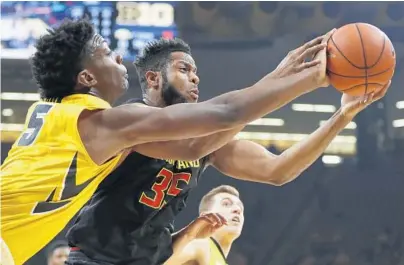  ?? CHARLIE NEIBERGALL/ASSOCIATED PRESS ?? Maryland’s Damonte Dodd (35), who finished with 10 points, reaches for a rebound with Iowa’s Tyler Cook during the first half.