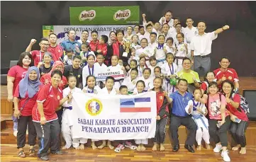  ??  ?? CONSECUTIV­E VICTORIES: SKA Penampang Branch team celebrate their first straight overall champions title at the end of the 20th Sabah State Primary School Karate Championsh­ip in Ranau on Sunday.