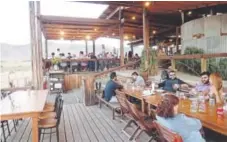  ?? Nicole Evatt, The Associated Press ?? Visitors dine at the rustic steakhouse Finca Altozano, which has sweeping views of Valle de Guadalupe, a relaxed corner of wine country in Mexico.