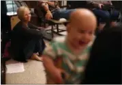  ?? BRYNN ANDERSON — THE ASSOCIATED PRESS FILE ?? In this file photo, Denise Wilkes, left, looks at baby Noah Burton, sitting on a fellow worshiper’s lap, during a church service in Birmingham, Ala. Emma and Noah continued their reign as the most popular baby names last year.