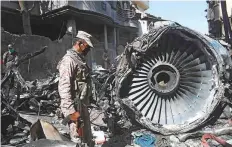  ?? AFP ?? Security personnel stand beside the wreckage of a plane at the site after a PIA aircraft crashed in Karachi.