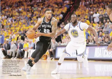  ??  ?? San Antonio Spurs forward Rudy Gay (22) drives past Golden State Warriors forward Draymond Green (23) in the third quarter in game one of the first round of the 2018 NBA playoffs at Oracle Arena.
— USA Today Sports