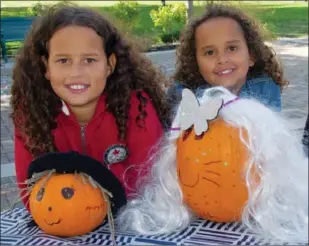  ??  ?? Abigayle Hudson, 9, and her sister Faith, 6, show off their pumpkin creations. Abigayle was trying for a Kawaii or cute look while Faith was trying to make her pumpkin look like her grandmothe­r.