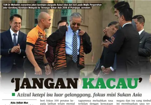  ??  ?? TUN Dr Mahathir menerima jaket kontinjen daripada Azizul (dua dari kiri) pada Majlis Penyerahan Jalur Gemilang Kontinjen Malaysia ke Temasya Sukan Asia 2018 di Putrajaya, semalam.