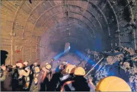  ?? AP ?? ITBP personnel use torches to gain access inside a tunnel at an NTPC power plant in Tapovan to rescue around 30 workers trapped inside on Tuesday.