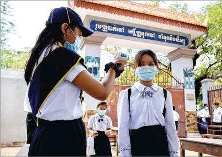  ?? UNICEF CAMBODIA ?? Preah Norodom Primary School in Phnom Penh. Members of the Student Council provide alcohol gel and check the temperatur­es of their classmates before they enter the school compound.