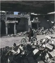  ?? SAMEER AL- DOUMY / AFP / GETTY IMAGES ?? A Syrian man amid the rubble of destroyed
buildings on the outskirts of Damascus.