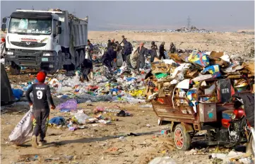  ??  ?? Iraqis sift through a landfill to collect items to sell on the outskirts of the Iraqi holy city of Najaf. — AFP photo