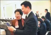  ?? ZOU HONG / CHINA DAILY ?? Margaret Chan Fung Fu-chun, a member of the 13th National Committee of the Chinese People’s Political Consultati­ve Conference and former directorge­neral of the World Health Organizati­on, interacts with a support staff member for the annual CPPCC...