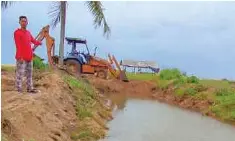  ?? ?? ZULKIFLI meninjau kerja menutup sementara sistem perparitan di kampung Teluk Bayu, semalam.