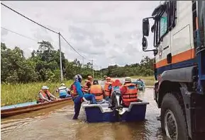 ?? (Foto ihsan APM) ?? Anggota APM Sarawak memindahka­n mangsa terjejas banjir di kawasan Tubau, Bintulu.