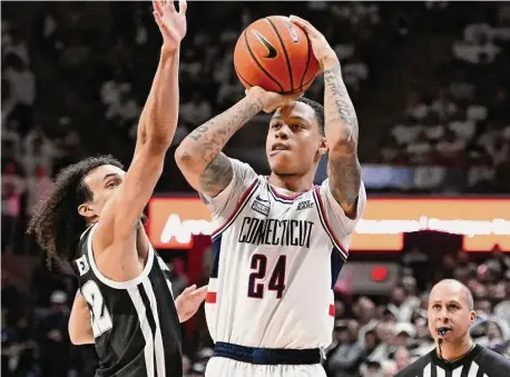  ?? Jessica Hill/Associated Press ?? UConn’s Jordan Hawkins (24) shoots while defended by Providence’s Devin Carter (22) on Feb. 22 in Storrs.