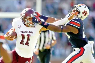  ?? AP Photo/Todd Kirkland ?? ■ Auburn defensive back Daniel Thomas (24) grabs the facemask of Texas A&amp;M quarterbac­k Kellen Mond (11) during the second half Nov. 3 in Auburn, Ala. Thomas received a penalty on the play.