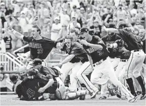  ?? BRUCE THORSON, USA TODAY SPORTS ?? Coastal Carolina players pile on in celebratio­n Thursday after beating Arizona to win the College World Series championsh­ip in Omaha.