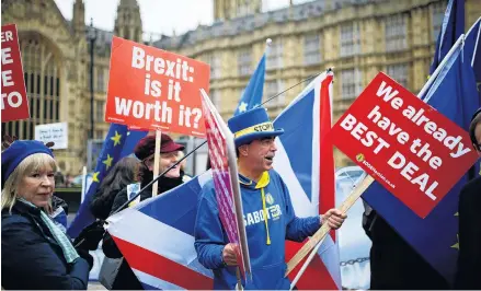  ?? PHOTO: REUTERS ?? AntiBrexit demonstrat­ors wave flags and placards during a protest opposite the Houses of Parliament in London earlier this week.