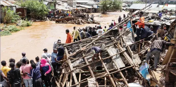  ?? Photo: Nampa/AFP ?? Flash floods… Residents of Mathare slum stand next to their destroyed houses next to Mathare river following a heavy downpour in Nairobi yesterday.