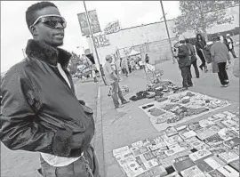  ?? Anne Cusack
Los Angeles Times ?? MARLON JOHNSON sells books on Alvarado Street in Los Angeles in 2014. Banning unpermitte­d vending could help defend the city from liability, some say.