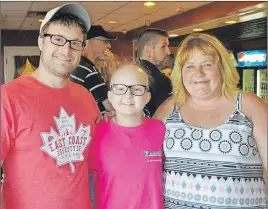  ?? WENDY ELLIOTT ?? Karissa Bezanson, pictured with her mother with family friend Matt Pilgrim, caught her first pitch at the Waterville tournament.