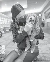  ?? RICHARD TSONG-TAATARII/MINNEAPOLI­S STAR TRIBUNE ?? Hope Lyberg holds a mini-goldendood­le at the Minneapoli­s airport before traveling to deliver the puppy to a new owner.