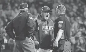  ?? GETTY IMAGES ?? Manager Joe Maddon of the Chicago Cubs argues an overturned call with umpires and is ejected in the eighth inning Wednesday during Game 4 of the National League Championsh­ip Series at Wrigley Field.