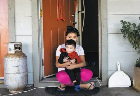  ?? Rachel Bujalski / Special to the Chronicle ?? Angellee Ribas, 10, and her baby brother, Fernando, 1, wait out the power blackout outside their apartment in Ukiah.