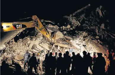  ?? Picture: REUTERS ?? EARTHQUAKE DEVASTATIO­N: Rescuers search in the night for survivors at a collapsed house in Pescara del Tronto