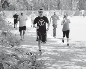  ?? Keith Bryant/The Weekly Vista ?? The police department’s applicants run along the trail at the Loch Lomond recreation area.