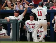  ?? John Bazemore / The Associated Press ?? Atlanta’s Ender Inciarte (11) is greeted at the dugout by hitting coach Kevin Seitzer and manager Brian Snitker after scoring on a Brandon Phillips double on Sunday.