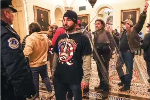  ?? The Associated Press ?? ■ Rioters are confronted by U.S. Capitol Police officers outside the Senate Chamber inside the Capitol, Wednesday, Jan. 6, 2021, in Washington. Speaker Kevin McCarthy’s decision to unleash a trove of Jan. 6 Capitol attack footage to Fox News’ Tucker Carlson has launched a wholesale rewriting of the history of the deadly siege. Carlson aired the first installmen­t of some 41,000 hours of security footage on his prime-time show and promised more Tuesday.