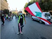  ?? AFP ?? A Lebanese protester waves the national flag during a recent demonstrat­ion in Beirut.